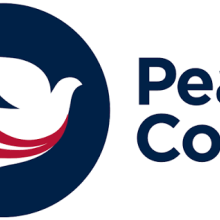 Peace Corps logo with a white dove and red stripes in a dark blue circle, next to the words “Peace Corps” in bold blue letters.