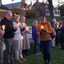 The lives of those enslaved were honored with a reading of their names, candle lighting, celebration, libation, remembrance and reflection at the Waterfront Ceremony. Dr Jordan and guests pictured holding candles. 