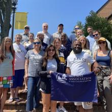 Group of alumni with alumni flag