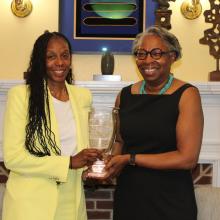 Athletic Director Crystal Gibson, left, stands with President Jordan, right. Both are holding the Presidents' Cup trophy 