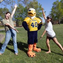 Two students flanking Solomon Seahawk mascot
