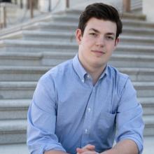 Portrait of Henry Marks sitting on steps outdoors 