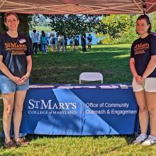Two women presenting info at an outdoor event
