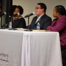 Four people sit at a table with microphones during a panel discussion at the Center for the Study of Democracy.