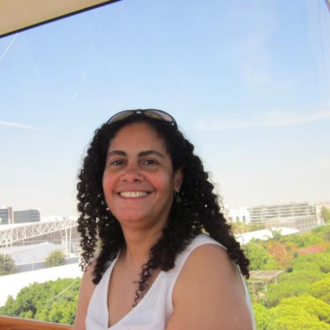 A woman in a white shirt smiles.