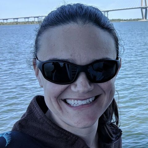 A woman with dark hair smiles.