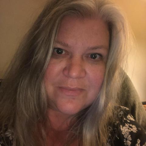 A woman with long, light hair smiles.