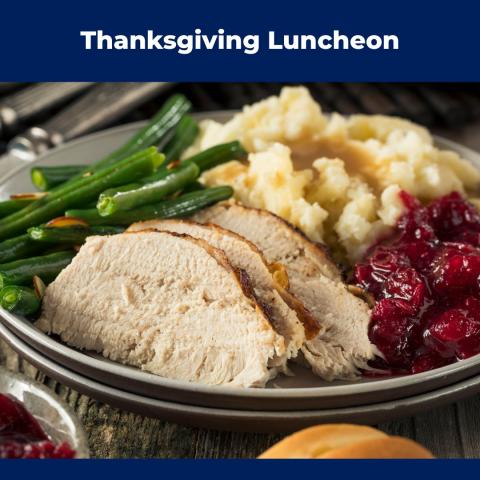 A plate of turkey slices, green beans, mashed potatoes with gravy, and cranberry sauce, set on a rustic table