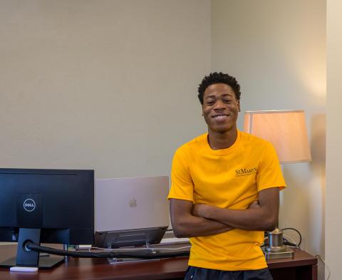 A man wearing a bright yellow shirt stands confidently, showcasing a vibrant and cheerful appearance.