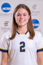 A female college soccer player wearing a white jersey with the number 2 on the front.