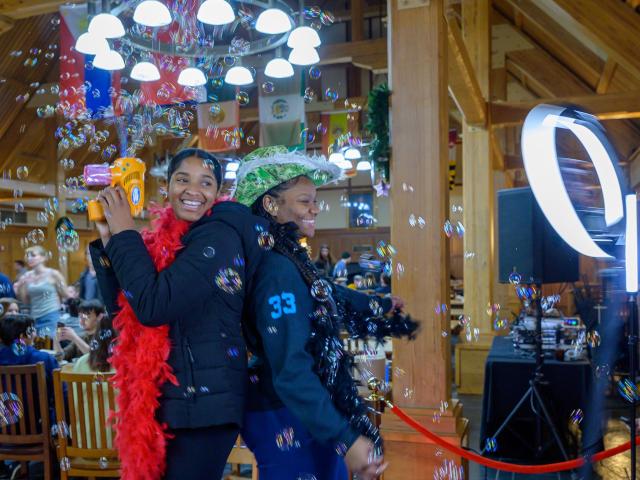 Two students pose in 360-degree video booth