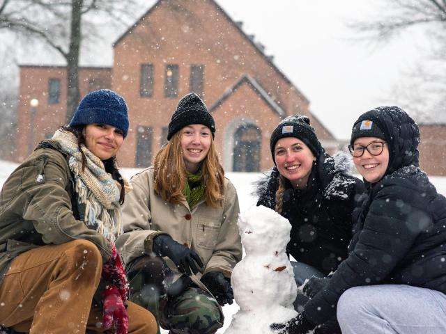 4 students building a snowman