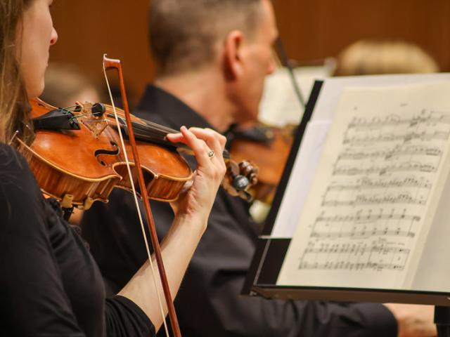 Close up of Violinists looking at sheet music, playing violin 