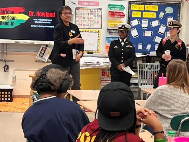 Dr. Howland talks with high school students in classroom 