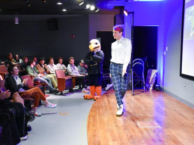 Gabe Cannanvo shows walks across stage at Cole cinema showing off business casual attire 