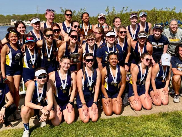A group of women in athletic clothing wearing championship medals
