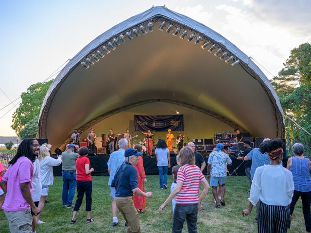 People dancing in front of band on outdoor stage