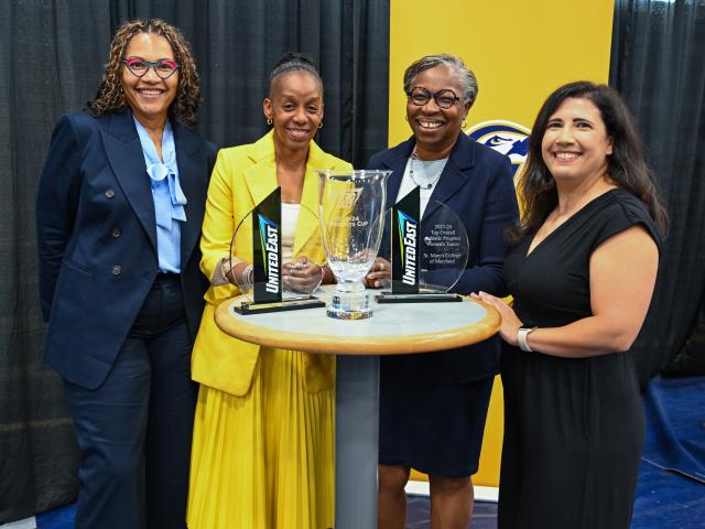 five women pose with the an award
