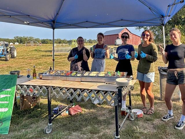 Members of the Veggie Co-op and Farm Club serve up fresh pizza on a beautiful night at Kate Farm.