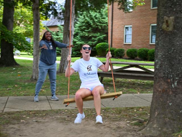 Alexis Hodges being pushed on the swing by Coach Potter