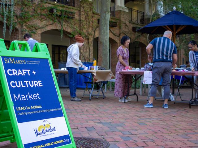 Students selling craft at tables on the Campus Center Patio