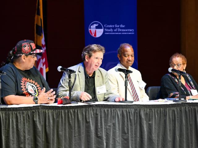Panelists on a stage speaking on civil rights