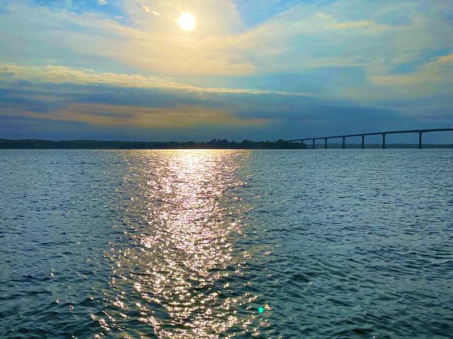 Sun reflection on water in Solomons Island with the Gov. Thomas Johnson Bridge in the background.