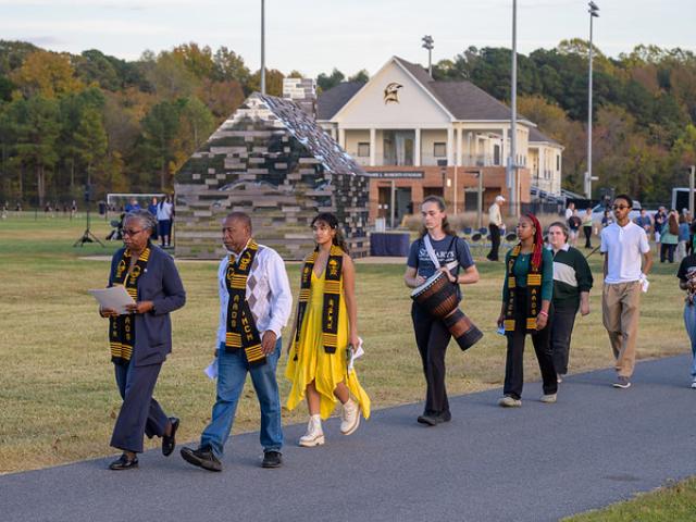 Several people and a drummer walking before the Commemorative to Enslaed Peoples of Southern Maryland