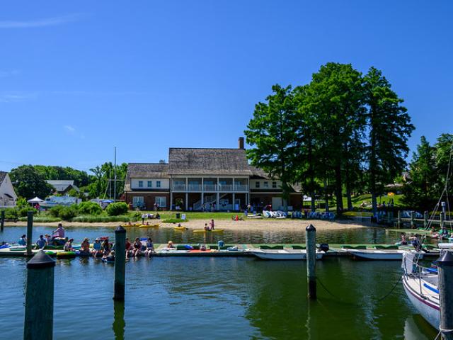 View of the River Center with sun bathers and kayakers in the foreground