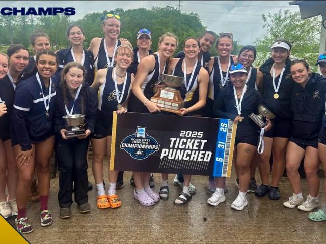 A women's rowing team poses outdoors with medals, trophies, and a sign that reads "2025 Ticket Punched" after winning a championship. #2025CHAMPS is in the top left corner.