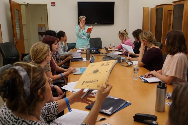 Classroom with a female professor leading a discussion with a group of students.