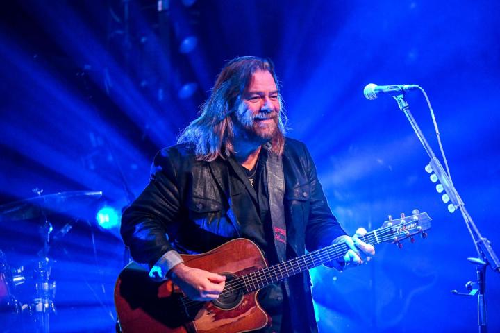 Alan Doyle playing a guitar.