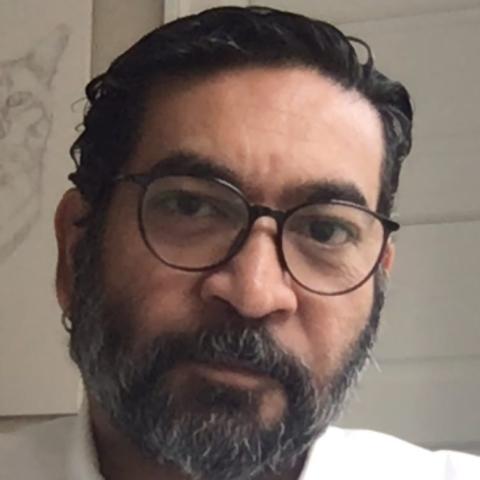 portrait photo of Colin Saldanha, looking pensively at the camera