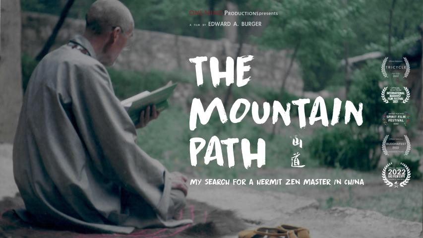 A person in traditional robes sits outdoors reading a book, with text overlay promoting the documentary "The Mountain Path" about a hermit Zen master in China.