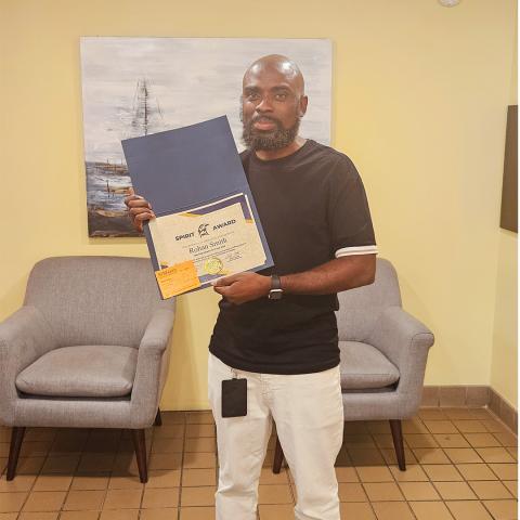 Rohan Smith holding the Seahawk Spirit Award certificate 