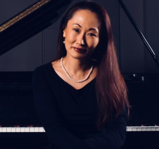 Rie Moore pictured sitting at a piano