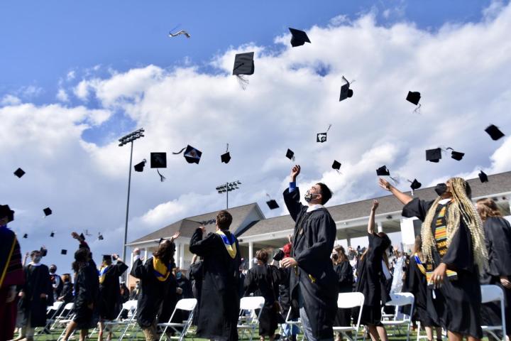 Graduates throwing their caps in the air after a Grad Walk shown