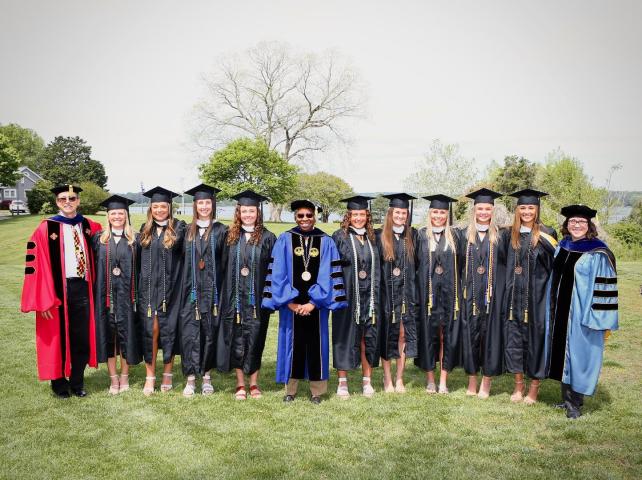 Graduates pose for photo with President Jordan on Townhouse Green