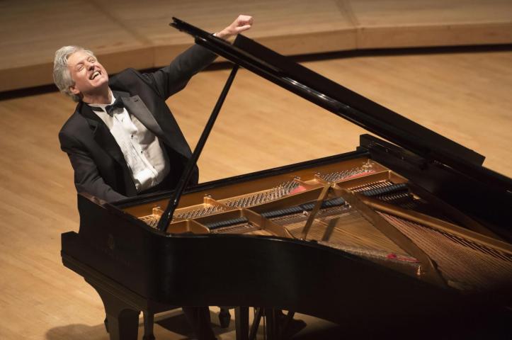 Pianist Brian Ganz sitting at a piano on stage