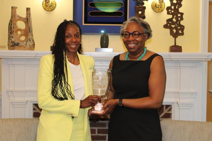 Athletic Director Crystal Gibson, left, stands with President Jordan, right. Both are holding the Presidents' Cup trophy 