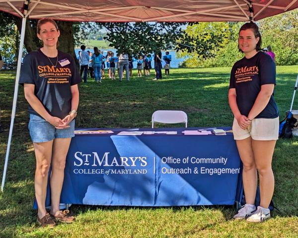 Two women presenting info at an outdoor event
