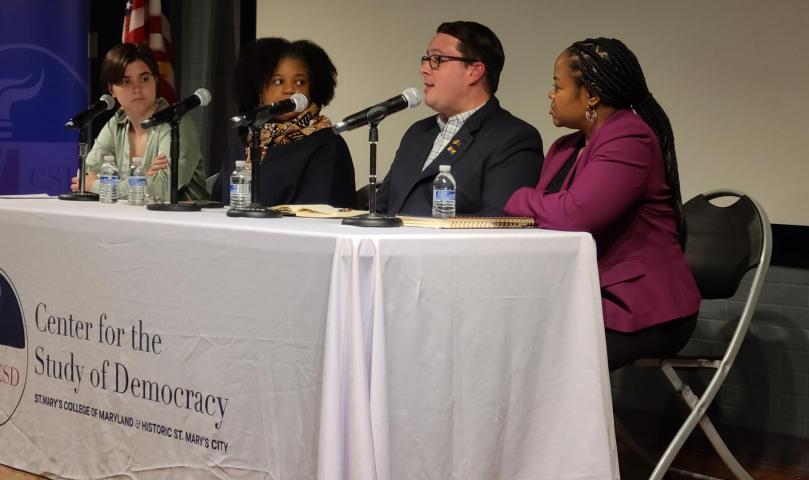 Four people sit at a table with microphones during a panel discussion at the Center for the Study of Democracy.
