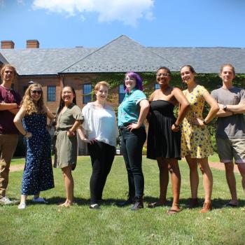 students posing in front of academic building pictured