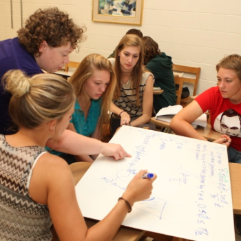 Physics professor Erin De Pree (standing) works with a group of students at St Mary’s College of Maryland. Credit: Michelle Milne