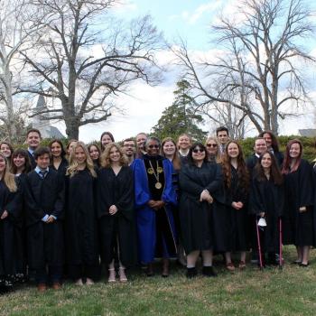 Phi Beta Kappa's Zeta Chapter of Maryland inductees pose for an image outside with Calvert Hall in background 