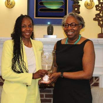 Athletic Director Crystal Gibson, left, stands with President Jordan, right. Both are holding the Presidents' Cup trophy 